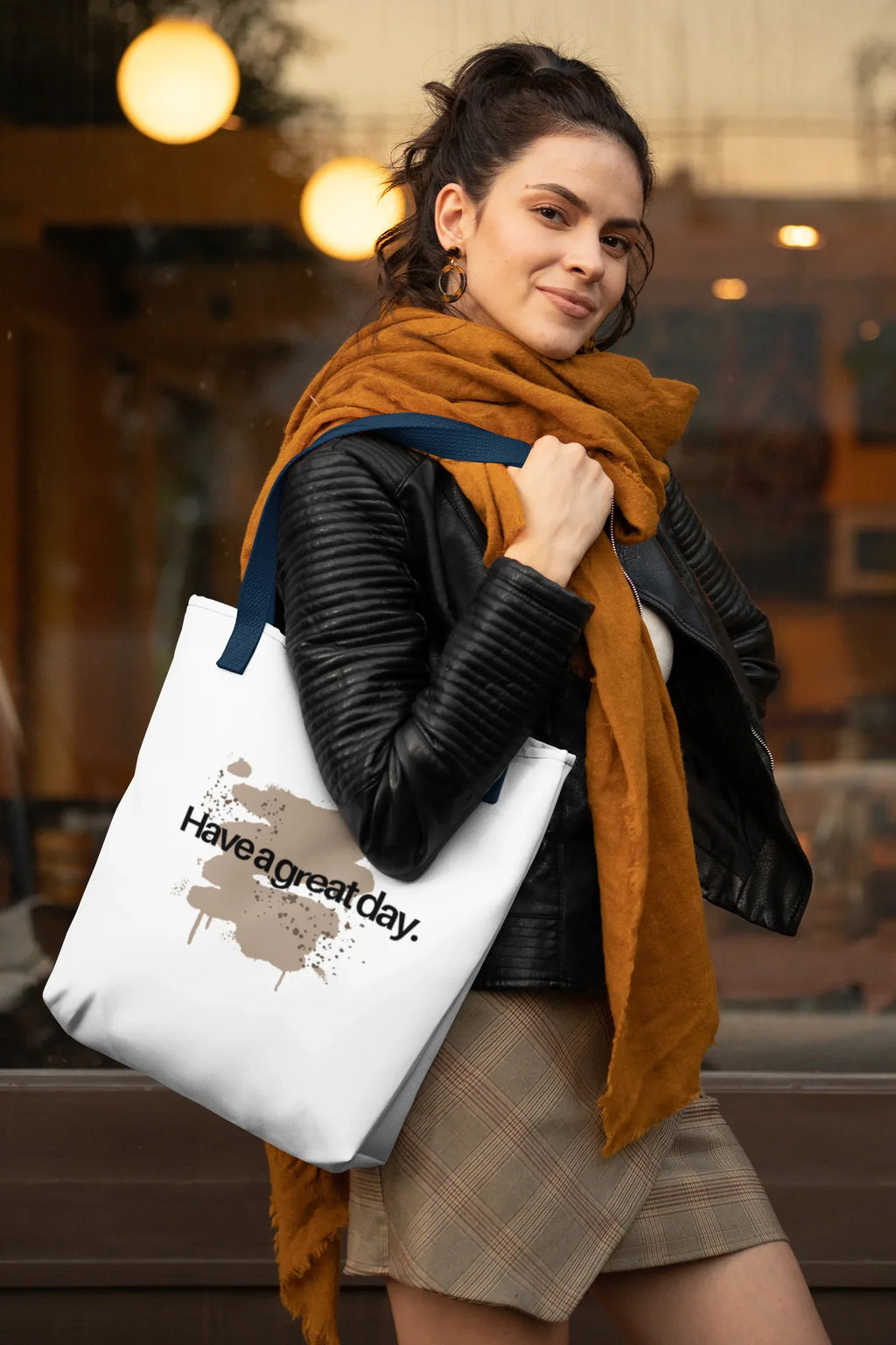 White tote bag with brown 'Have a great day' print, carried by person on shoulder