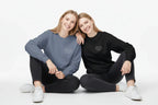 Blue and black crewneck sweatshirts with small chest text, worn by models