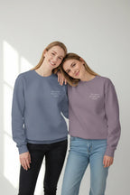 Mauve and blue crewneck sweatshirts with small chest text, worn by models
