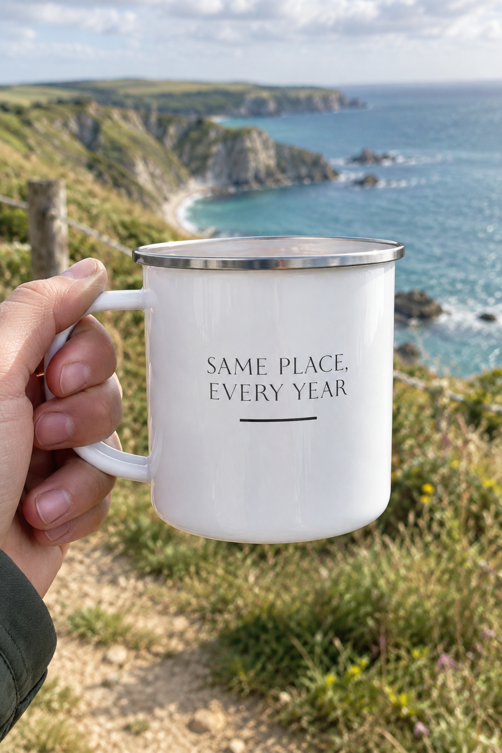 White enamel camping mug with 'Same place, every year' text, silver rim