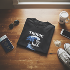 Black T-shirt featuring “Tropic like it’s hot.” tropical print with palm and beach chair
