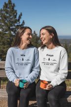Two crewneck sweatshirts: light blue Mia and white Freya with coffee, trees, mountains