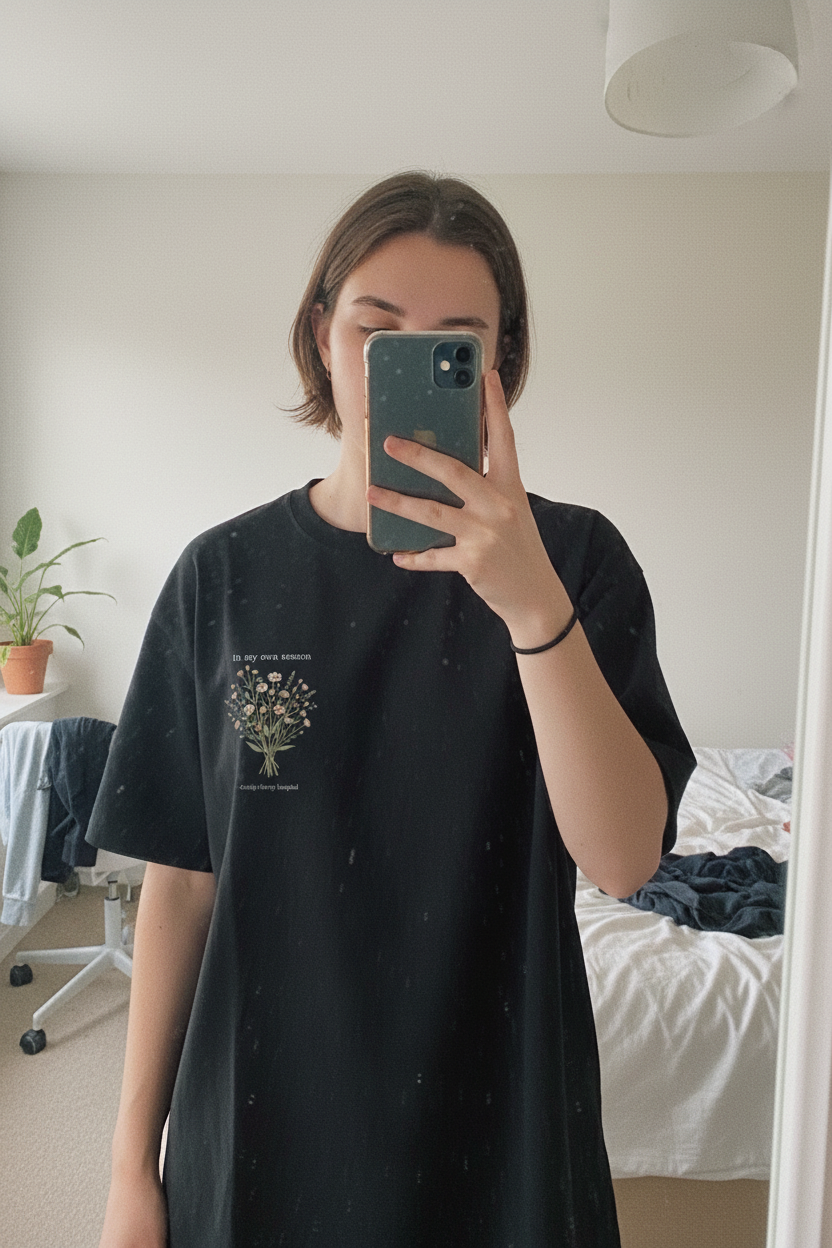 Black crew-neck t-shirt on a person with small botanical bouquet graphic