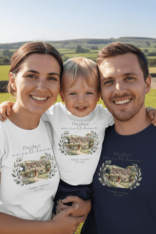 White T-shirts with “The place we call home” house wreath graphic on close family portrait