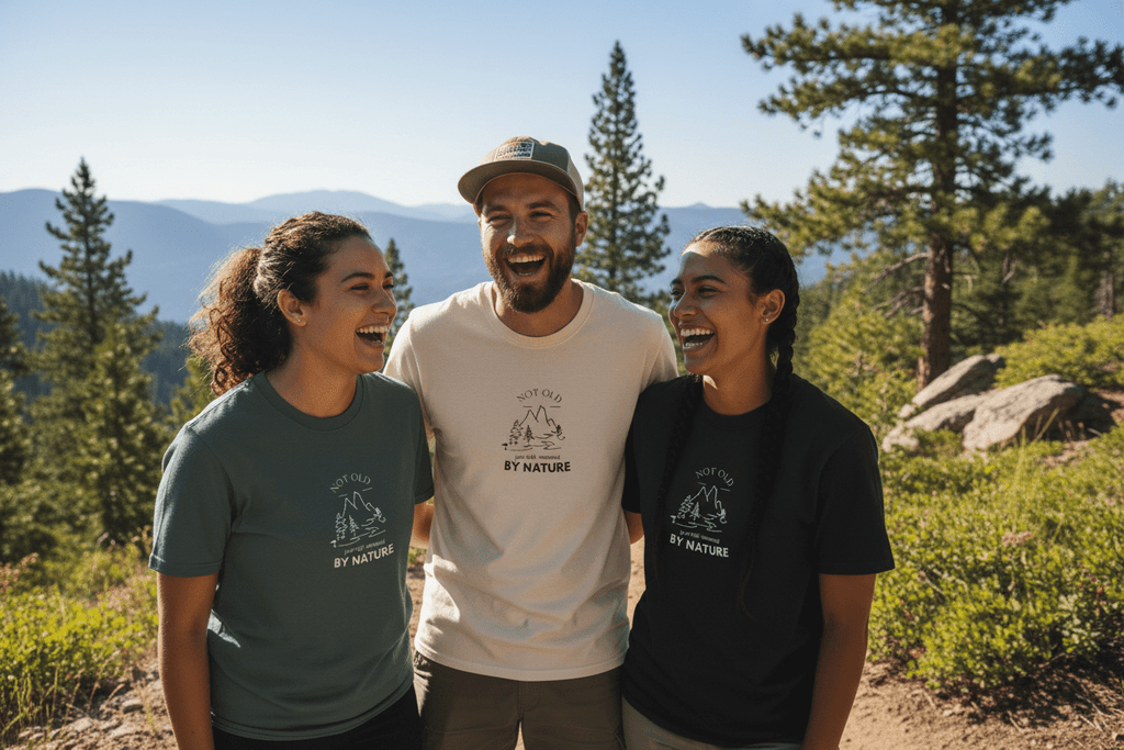 Dark green and black T-shirts with 'BY NATURE' mountain graphics on three people