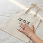 Cream cotton tote bag with ring question graphic and cursive text on front