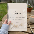 A5 lined notebook with cream cover, moon design, and Trust the Timing of Your Life—ALICE