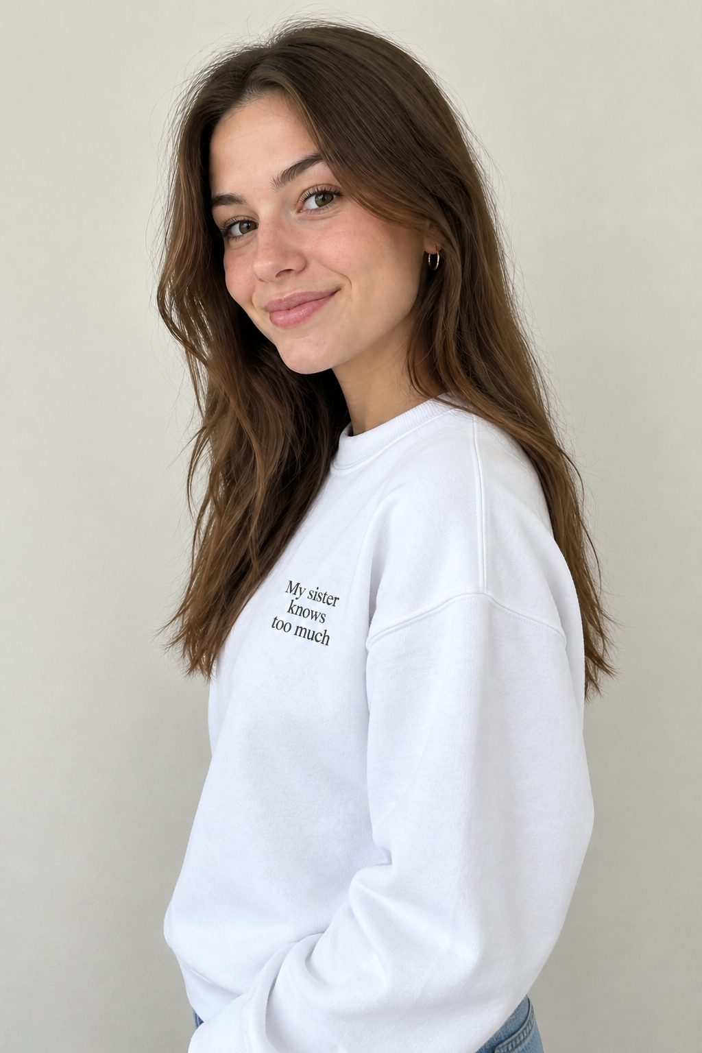 White crewneck sweatshirt with small front text "My sister knows too much"