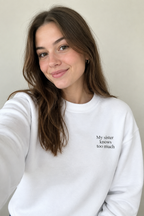 White crewneck sweatshirt with small front text "My sister knows too much"