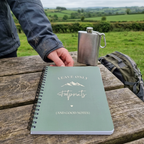 A5 hiking notebook with mint-green cover, spiral binding, footprints and mountain text