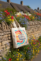 White canvas tote bag with retro 'good vibes' logo on front, sturdy handles