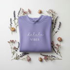 Lavender hoodie with drawstring hood and “delulu vibes” slogan with small heart