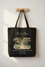 Black tote bag with watercolor forest graphic and script family name