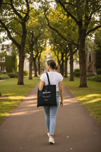 Black canvas tote bag with graduation design and handles, back view