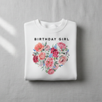 White sweatshirt with “BIRTHDAY GIRL” text and floral heart bouquet graphic