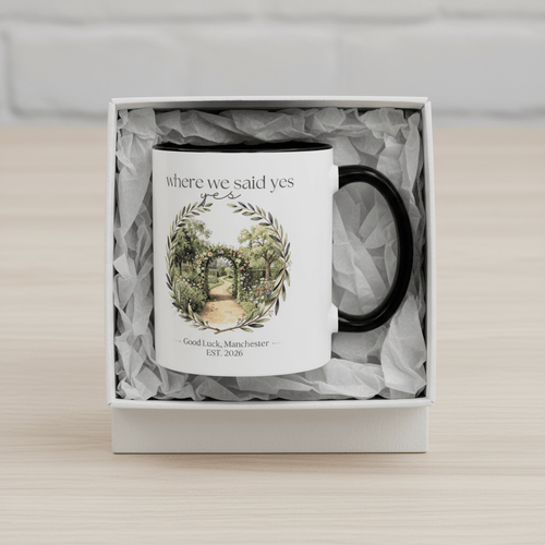 White ceramic mug with black handle in gift box with grey shredded filler