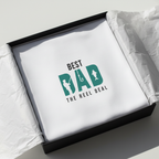 White t-shirt with small green “BEST DAD” paw/reel graphic, crew neck