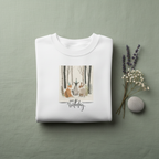 White sweatshirt with crew neck and woodland animals Happy Birthday graphic on chest
