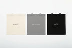 Three cotton tote bags: cream 'grounded', grey 'less, but better', black 'soft life'.