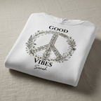 White folded unisex hoodie with front graphic: floral peace sign and "GOOD VIBES"