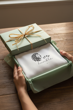 White hooded sweatshirt with lion Stay Humble graphic, in a green gift box with bow