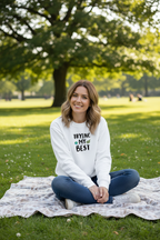 White sweatshirt on woman sitting in park, 'TRYING MY BEST' quote with globe graphic