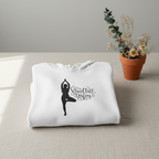 White hoodie folded, with hood and front yoga silhouette logo graphic.