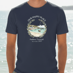 Navy T-shirt on model, chest graphic wreath with seaside scene and “since 2023”