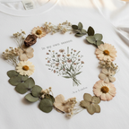 White crew-neck t-shirt with botanical wreath graphic and 'In my own season' text