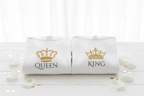White hooded sweatshirt pair with QUEEN and KING crown logos, folded on a stone surface