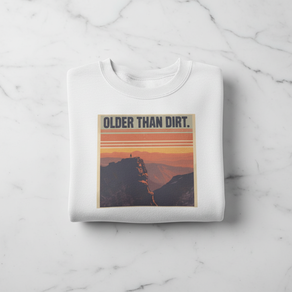 White crewneck sweatshirt with mountain sunset graphic and banner-style text