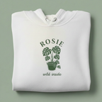 White hoodie with front hood and eyelet drawstrings; potted palm graphic with “ROSIE”.