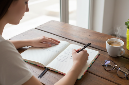Woman's hands writing with pen and coffee