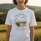 White T-shirt with “OUR HAPPY PLACE” scenic wreath graphic and small location text