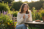 Personalised rainbow mug with name CHLOE, held on a garden patio bench.