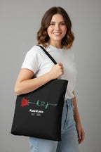 Black tote bag with red rose logo and 'Katie & Jake' EST. 2025 print