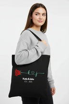 Black personalized rose tote bag with red rose print and 'Katie&Jake' text