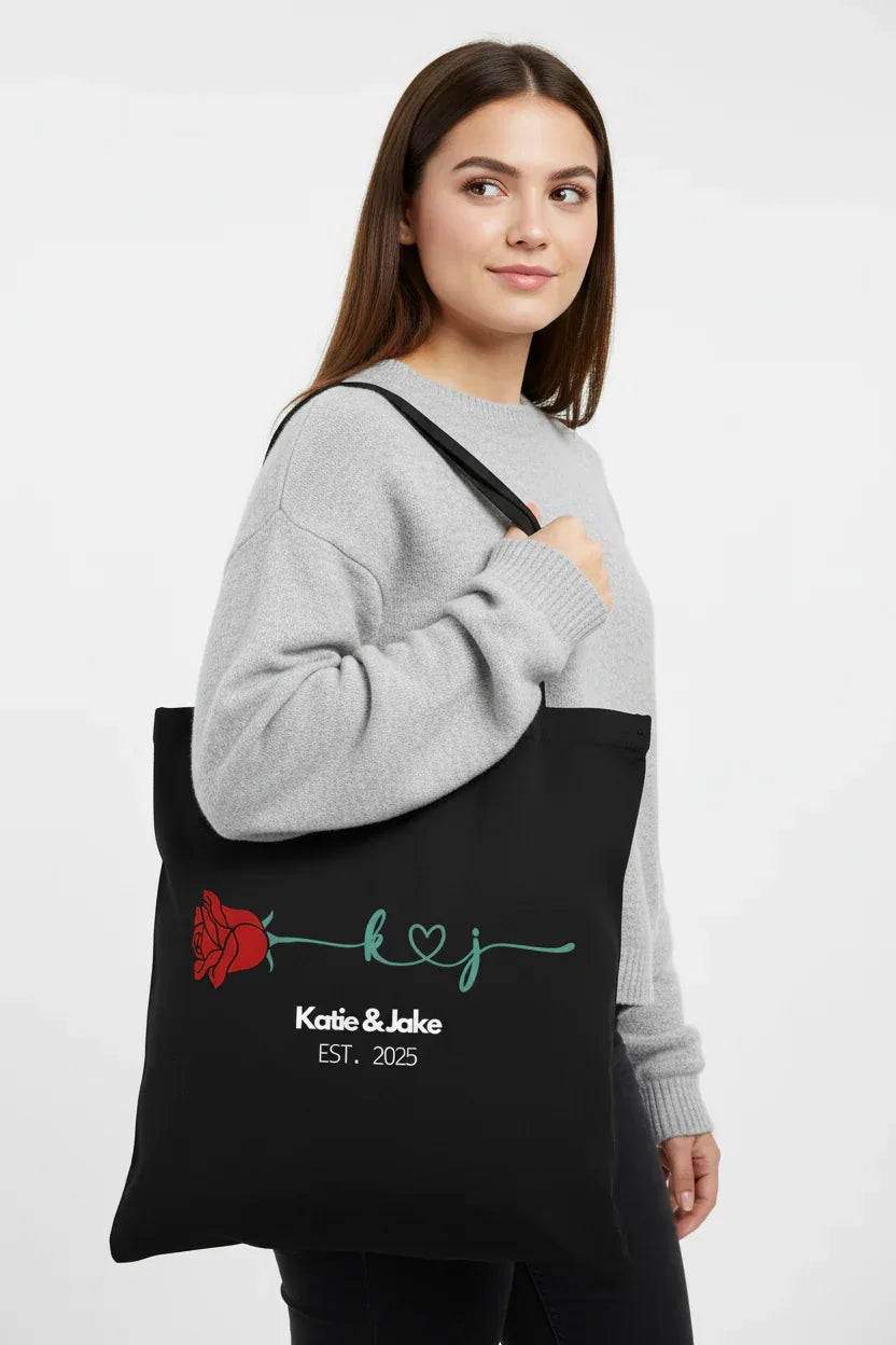 Black personalized rose tote bag with red rose print and 'Katie&Jake' text