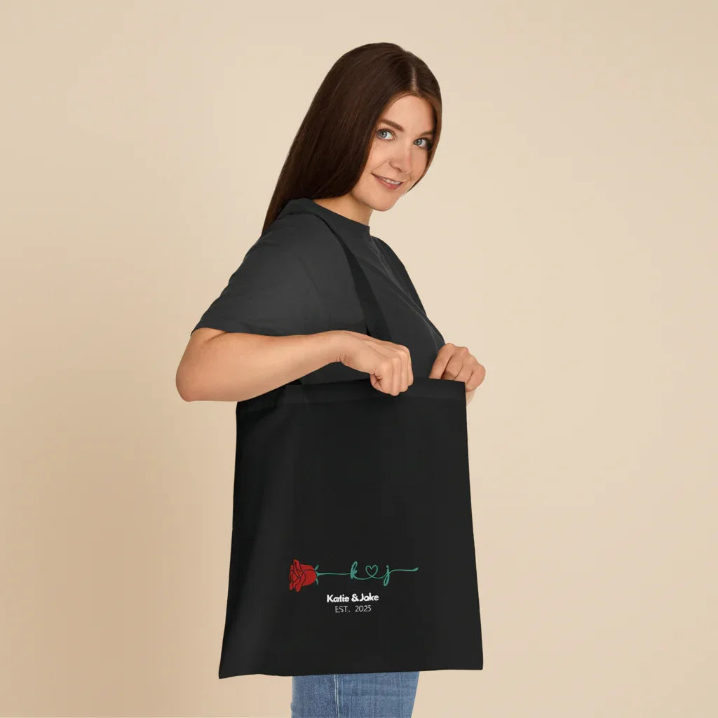 Black personalized rose tote bag with red rose print and 'Katie&Jake' text